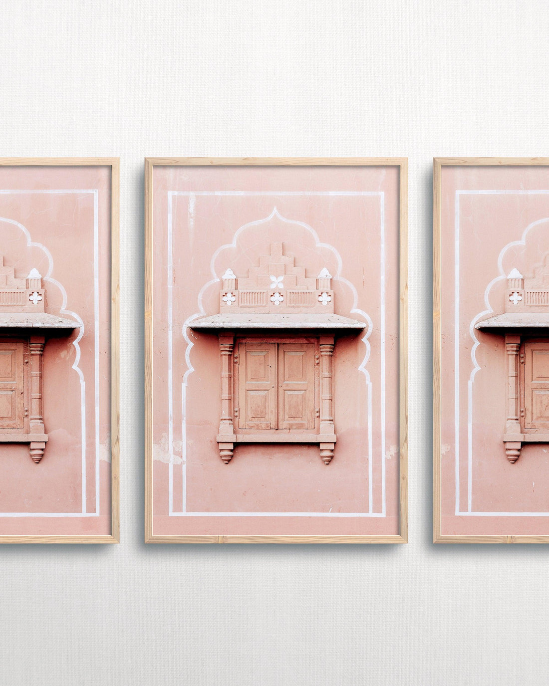 framed art piece on white wall. Photograph of pink architecture in India in frame